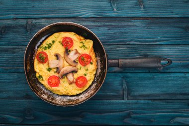 Mantar ve taze sebze ve fındık bir tavada omlet. Ahşap bir arka plan üzerinde. Üstten Görünüm. Kopya alanı.