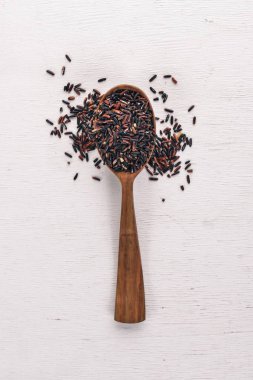 Siyah vahşi kuru pirinç üzerine bir kaşık. Ahşap bir arka plan üzerinde. Üstten Görünüm. Kopya alanı.