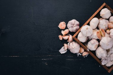 Sarımsak ahşap sepet içinde. Taze sarımsak ahşap arka plan üzerinde. Üstten Görünüm. Metin için boş alan.