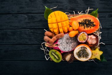 Meyve dragon, papaya, maracuya, kivi, mango ve granadilla mezarda. Taze tropikal meyve. Ahşap bir arka plan üzerinde. Üstten Görünüm. Kopya alanı.