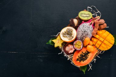Meyve dragon, papaya, maracuya, kivi, mango ve granadilla mezarda. Taze tropikal meyve. Ahşap bir arka plan üzerinde. Üstten Görünüm. Kopya alanı.