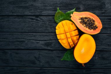 Mango ve Papaya. Tropikal meyve. Ahşap bir arka plan üzerinde. Üstten Görünüm. Kopya alanı.