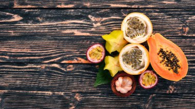 Granadilla, maracuya, mangosten, papaya. Taze tropikal meyve. Ahşap bir arka plan üzerinde. Üstten Görünüm. Kopya alanı.