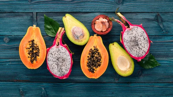 Dragon Fruit, Avocado, Papaya and Mangosteen. Tropical Fruits. On a wooden background. Top view. Copy space.