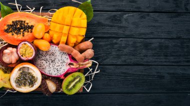 Meyve dragon, papaya, maracuya, kivi, mango ve granadilla mezarda. Taze tropikal meyve. Ahşap bir arka plan üzerinde. Üstten Görünüm. Kopya alanı.