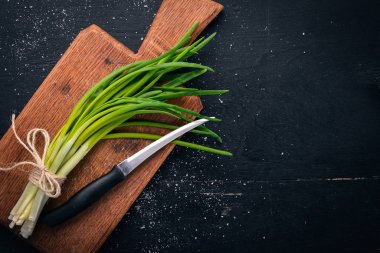Ahşap arka plan üzerinde taze yeşil soğan. Üstten Görünüm. Metniniz için boş alan.