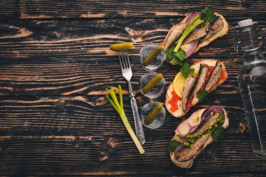 Votka ve sandviç hamsi ve havyar, soğan ve maydanoz, ahşap arka plan üzerinde bir dizi. Üstten Görünüm. Kopya alanı.