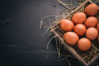Tavuk ahşap sepet içinde çiğ yumurta. Ahşap bir arka plan üzerinde. Üstten Görünüm. Kopya alanı.
