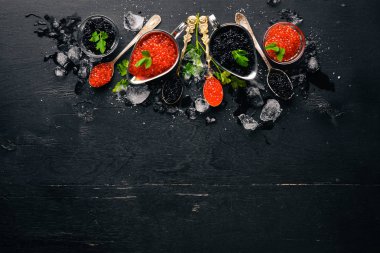 Ahşap arka plan üzerinde siyah ve kırmızı havyar kaşıkla. Üstten Görünüm. Metin için boş alan.