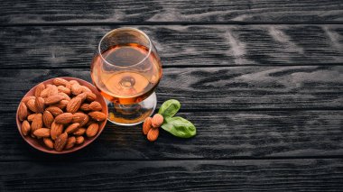 Amaretto badem likörü. Badem ahşap arka plan üzerinde. İtalyan içki üstten görünüm. Metin için boş alan.