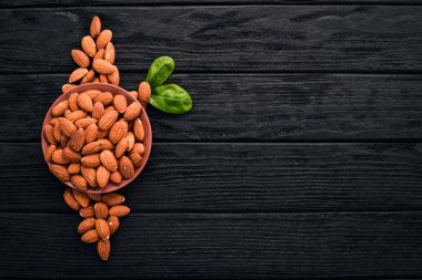 Badem fındık koyu ahşap arka plan üzerinde. Sağlıklı aperatifler. Üstten Görünüm. Metin için boş alan.