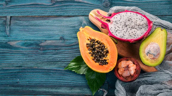 Dragon Fruit, Avocado, Papaya and Mangosteen. Tropical Fruits. On a wooden background. Top view. Copy space.