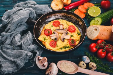 Mantar ve taze sebze ve fındık bir tavada omlet. Ahşap bir arka plan üzerinde. Üstten Görünüm. Kopya alanı.