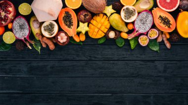 Tropikal meyveler, papaya, Dragon meyve, rambutan, demirhindi, kaktüs meyve, avokado, granadilla, carambola, Kamkat, mango, mangosten, Çarkıfelek, Hindistan cevizi. Ahşap bir arka plan üzerinde.