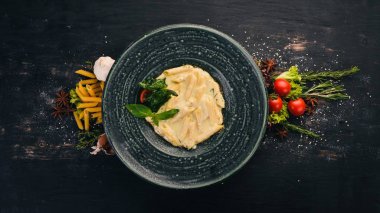 Brie peyniri ile makarna bölme. İtalyan mutfağı. Üstten Görünüm. Siyah ahşap arka plan üzerinde. Kopya alanı.