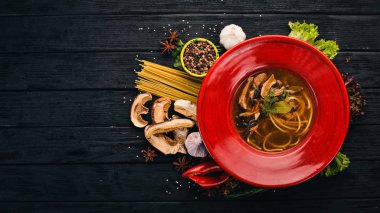 Spagetti yapıştır ile mantar çorbası. Üstten Görünüm. Siyah ahşap arka plan üzerinde. Kopya alanı.