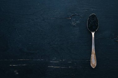 Ahşap arka plan üzerinde siyah havyar kaşıkla. Üstten Görünüm. Metin için boş alan.