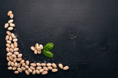 Antep fıstığı koyu ahşap arka plan üzerinde. Sağlıklı aperatifler. Üstten Görünüm. Metin için boş alan.