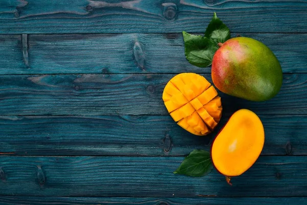 Mango. Tropikal meyve. Ahşap bir arka plan üzerinde. Üstten Görünüm. Kopya alanı.