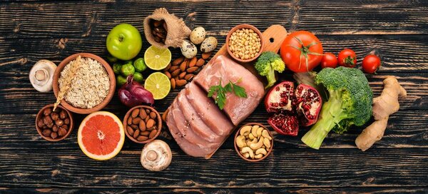 Здоровое питание. Сырое мясо, авокадо, брокколи, свежие овощи, орехи и фрукты. На деревянном фоне. Вид сверху. Копирование пространства
.