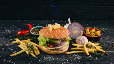 Burger ananas, sığır eti ve marul. Amerikan geleneksel yemekleri. Siyah ahşap arka plan üzerinde. Kopya alanı.