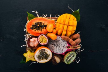 Meyve dragon, papaya, maracuya, kivi, mango ve granadilla mezarda. Taze tropikal meyve. Ahşap bir arka plan üzerinde. Üstten Görünüm. Kopya alanı.