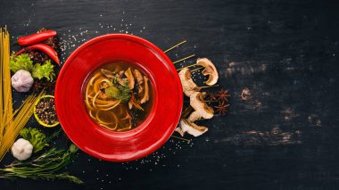 Spagetti yapıştır ile mantar çorbası. Üstten Görünüm. Siyah ahşap arka plan üzerinde. Kopya alanı.