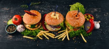 Balık, et ve sebze Burger ayarlayın. Üstten Görünüm. Metniniz için boş alan. Ahşap bir arka plan üzerinde.