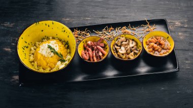 Peynir, sosis, mantar ve domuz yağı ile Banosh. Sıcak meze. Üstten Görünüm. Siyah ahşap arka plan üzerinde. Kopya alanı.