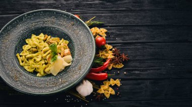 Ispanak ve deniz ürünleri ile makarna Farfelli. İtalyan mutfağı. Üstten Görünüm. Siyah ahşap arka plan üzerinde. Kopya alanı.
