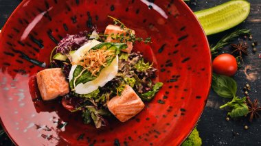 Sezar salatası somon ve haşlanmış yumurta. Üstten Görünüm. Siyah ahşap arka plan üzerinde. Kopya alanı.