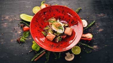 Sezar salatası somon ve haşlanmış yumurta. Üstten Görünüm. Siyah ahşap arka plan üzerinde. Kopya alanı.