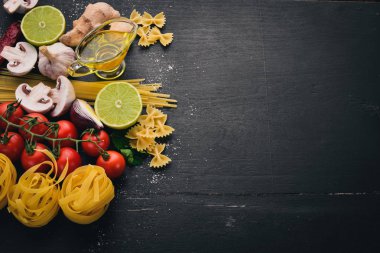 Bir makarna, erişte, makarna, tagliatelle, fettuccine, dizi Farfalle. İtalyan yemek, taze sebze ve baharat. Siyah ahşap arka plan üzerinde. Üstten Görünüm. Kopya alanı.