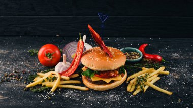 Burger chili, pastırma ve marul. Amerikan geleneksel yemekleri. Siyah ahşap arka plan üzerinde. Kopya alanı.
