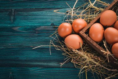 Tavuk ahşap sepet içinde çiğ yumurta. Ahşap bir arka plan üzerinde. Üstten Görünüm. Kopya alanı.
