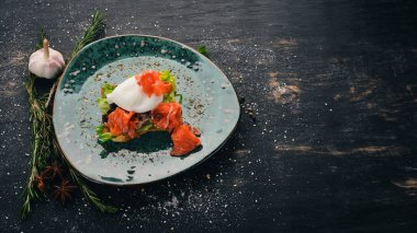 Kahvaltı. Haşlanmış yumurta, tost ekmek üzerinde marul üzerinde somon. Siyah ahşap arka plan üzerinde. Kopya alanı.