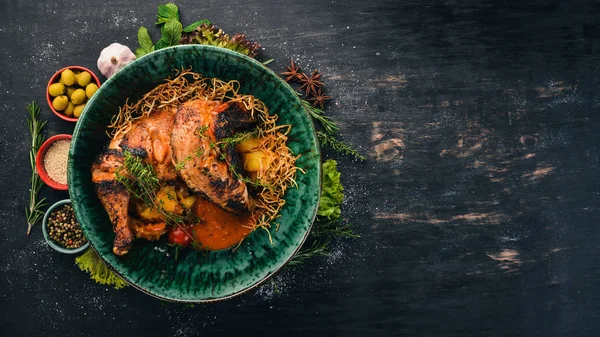 Grilled chicken cooked in a hoster. Meat. Top view. On a black wooden background. Copy space.