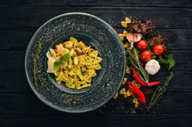 Ispanak ve deniz ürünleri ile makarna Farfelli. İtalyan mutfağı. Üstten Görünüm. Siyah ahşap arka plan üzerinde. Kopya alanı.