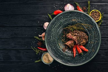 Biberli biftek gelen sığır eti. Et. Sıcak meze. Üstten Görünüm. Siyah ahşap arka plan üzerinde. Kopya alanı.
