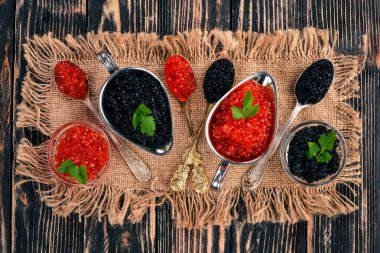 Ahşap arka plan üzerinde siyah ve kırmızı havyar kaşıkla. Üstten Görünüm. Metin için boş alan.