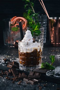 Alkollü kokteyl Beyaz Rus. Siyah bir ahşap zemin üzerine kahve likör.