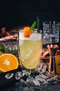 Alkol kokteyl Pinacolada. Orange, likör, buz. Siyah bir ahşap arka plan üzerinde.