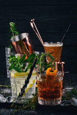 İki alkollü kokteyl cin tonik, Negroni. Siyah bir ahşap arka plan üzerinde.