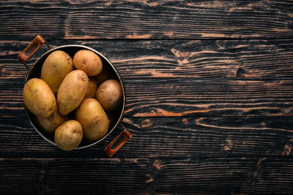 生のジャガイモ 茶色の木製の背景 本文の空きスペース トップ ビュー — ストック写真