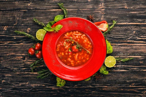 Tomato soup of corn, chicken and chili pepper. Top view. On a black wooden background. Copy space.