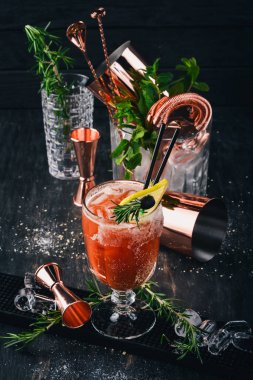 Alkollü kokteyl Bloody Mary. Biberiye ve domates suyu. Siyah bir ahşap arka plan üzerinde.