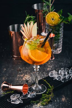 Barda alkollü kokteyl Aperol. Turuncu. Siyah bir ahşap arka plan üzerinde.