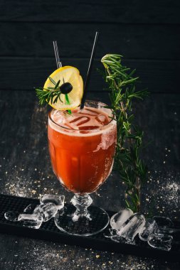 Alkollü kokteyl Bloody Mary. Biberiye ve domates suyu. Siyah bir ahşap arka plan üzerinde.