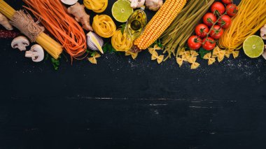 Bir makarna, erişte, makarna, tagliatelle, fettuccine, dizi Farfalle. İtalyan yemek, taze sebze ve baharat. Siyah ahşap arka plan üzerinde. Üstten Görünüm. Kopya alanı.