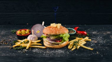 Burger ananas, sığır eti ve marul. Amerikan geleneksel yemekleri. Siyah ahşap arka plan üzerinde. Kopya alanı.